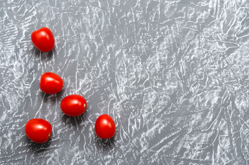 Cherry tomatoes are bright juicy and ripe on a gray background. Healthy food concept. Symbolic image. Copy space.