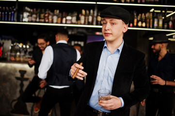 Stylish arab man against group of handsome retro well-dressed guys gangsters spend time at club, drinking on bar counter. Multiethnic male bachelor mafia party in restaurant.