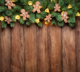 Christmas wreath with gingerbread man on wooden background