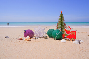 Christmas decorations, baubles and christmas tree near ocean on a bright and sunny day. New Year concept.snowflake on the sand. Winter holidays in the tropics,sandy beach with ocean.Copy space