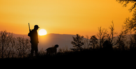 Hunting silhouette at dawn with dog