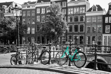 An azure bike on the streets of Amsterdam. Symbol for clean and ecological urban transport. Isolated in a black and white background. 