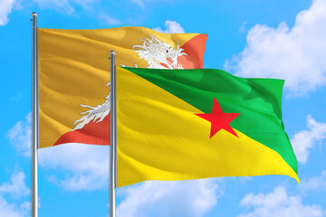 French Guiana and Bhutan national flag waving in the windy deep blue sky. Diplomacy and international relations concept.
