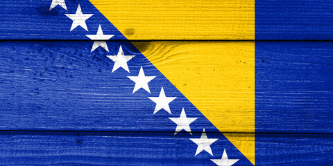 Bosnia and Herzegovina flag painted on old wood plank background. Brushed natural light knotted wooden board texture. Wooden texture background flag of Bosnia and Herzegovina