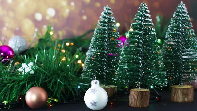 Close up of Christmas decoration with garlands, blinking lights, ornaments and pine trees