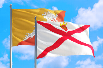 Jersey and Bhutan national flag waving in the windy deep blue sky. Diplomacy and international relations concept.