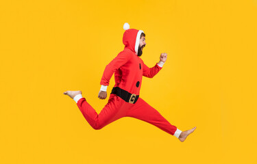 Fototapeta na wymiar Being surprised. concept of freedom. happy male has funny look. winter holiday party. new year fun. santa ctlaus in hat hurry up to xmas shopping sales. running bearded man in christmas costume