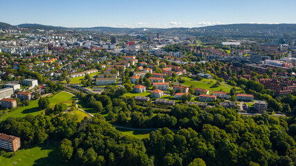 Fototapeta na wymiar Oslo, Norway. Beautiful panoramic aerial view photo from flying drone for Oslo city new neighborhoods and new homes. Against the background of the mountains and blue sky on a sunny summer day. (Series