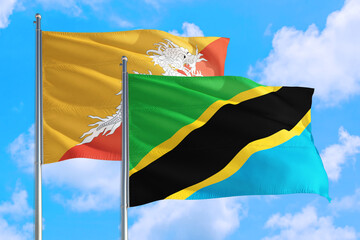 Tanzania and Bhutan national flag waving in the windy deep blue sky. Diplomacy and international relations concept.