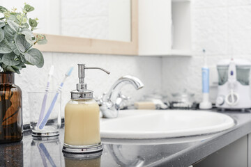 Fototapeta na wymiar Bathroom set with glass liquid soap dispenser