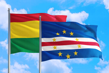 Fototapeta na wymiar Cape Verde and Bolivia national flag waving in the windy deep blue sky. Diplomacy and international relations concept.
