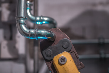 Plumber using pipe fastener or battery press tool to crimp heating or warm water pipes together....