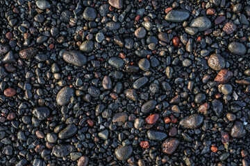 Black wet sea stones on beach