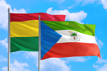 Equatorial Guinea and Bolivia national flag waving in the windy deep blue sky. Diplomacy and international relations concept.