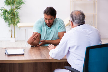 Injured young man visiting old doctor