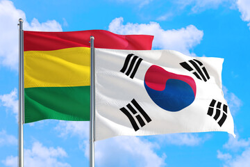 South Korea and Bolivia national flag waving in the windy deep blue sky. Diplomacy and international relations concept.