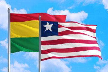 Liberia and Bolivia national flag waving in the windy deep blue sky. Diplomacy and international relations concept.