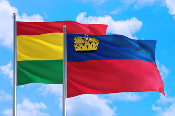 Liechtenstein and Bolivia national flag waving in the windy deep blue sky. Diplomacy and international relations concept.