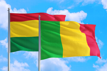 Mali and Bolivia national flag waving in the windy deep blue sky. Diplomacy and international relations concept.