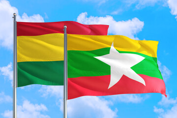 Myanmar and Bolivia national flag waving in the windy deep blue sky. Diplomacy and international relations concept.