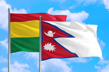 Nepal and Bolivia national flag waving in the windy deep blue sky. Diplomacy and international relations concept.
