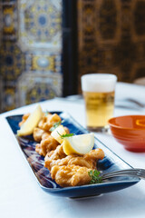 Battered calamari with salad and accompanied by a beer
