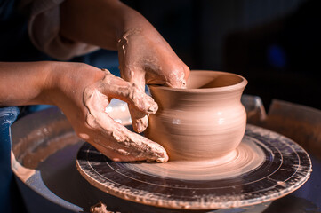 Creating a jar or vase. Master crock. Making clay jug. The sculptor in the workshop makes a jug out of earthenware closeup. Potter's wheel. Pottery concept.