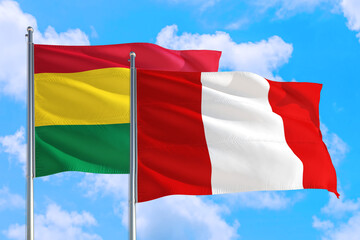 Peru and Bolivia national flag waving in the windy deep blue sky. Diplomacy and international relations concept.