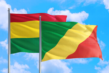 Republic Of The Congo and Bolivia national flag waving in the windy deep blue sky. Diplomacy and international relations concept.