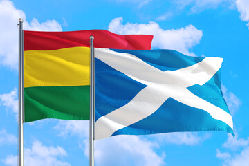 Scotland and Bolivia national flag waving in the windy deep blue sky. Diplomacy and international relations concept.