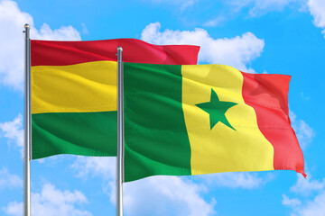 Senegal and Bolivia national flag waving in the windy deep blue sky. Diplomacy and international relations concept.