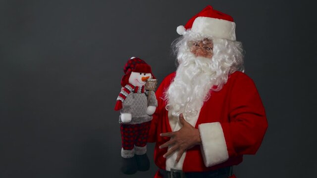 Papa noel con bolsa de regalos buscando saludando caminando alegre presentes