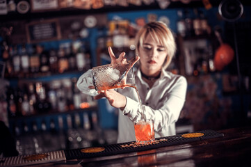 Girl bartender concocts a cocktail at the taproom