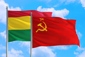 Soviet Union and Bolivia national flag waving in the windy deep blue sky. Diplomacy and international relations concept.