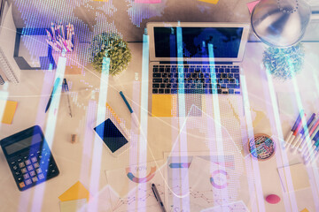 Double exposure of forex chart drawing over table background with computer. Concept of financial research and analysis. Top view.