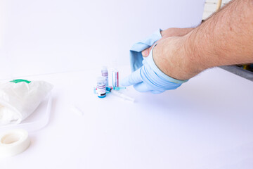 Fototapeta premium Doctor, nurse, scientist, researcher hand in blue gloves holding flu, measles, coronavirus, covid-19 vaccine disease preparing for human clinical trials vaccination shot, medicine and drug concept.