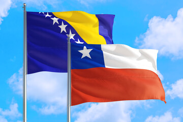 Chile and Bosnia Herzegovina national flag waving in the windy deep blue sky. Diplomacy and international relations concept.