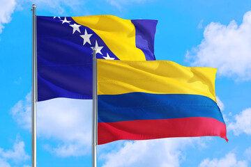 Colombia and Bosnia Herzegovina national flag waving in the windy deep blue sky. Diplomacy and international relations concept.