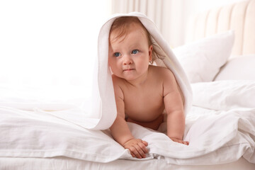 Obraz na płótnie Canvas Cute little baby with soft towel on bed after bath