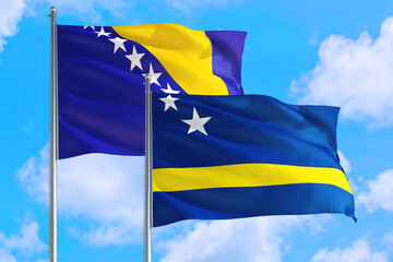 Curacao and Bosnia Herzegovina national flag waving in the windy deep blue sky. Diplomacy and international relations concept.