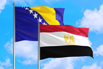 Egypt and Bosnia Herzegovina national flag waving in the windy deep blue sky. Diplomacy and international relations concept.