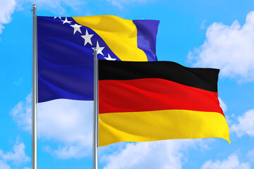 Germany and Bosnia Herzegovina national flag waving in the windy deep blue sky. Diplomacy and international relations concept.