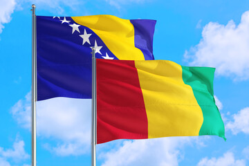 Guinea Bissau and Bosnia Herzegovina national flag waving in the windy deep blue sky. Diplomacy and international relations concept.