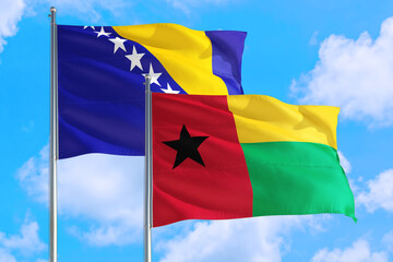 Guinea and Bosnia Herzegovina national flag waving in the windy deep blue sky. Diplomacy and...
