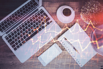 Financial market graph and top view computer on the desktop background. Double exposure. Investment concept.