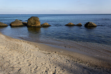 Rocks into panoramic blue water horizon view with sand sky and empty beach Black sea coast 