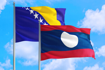 Laos and Bosnia Herzegovina national flag waving in the windy deep blue sky. Diplomacy and...