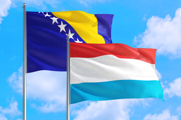 Luxembourg and Bosnia Herzegovina national flag waving in the windy deep blue sky. Diplomacy and international relations concept.
