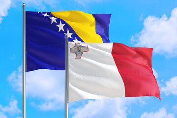 Malta and Bosnia Herzegovina national flag waving in the windy deep blue sky. Diplomacy and international relations concept.