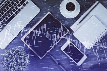 Double exposure of forex chart hologram over desktop with phone. Top view. Mobile trade platform concept.